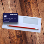 Credit card, envelope and pencil on a wooden table.